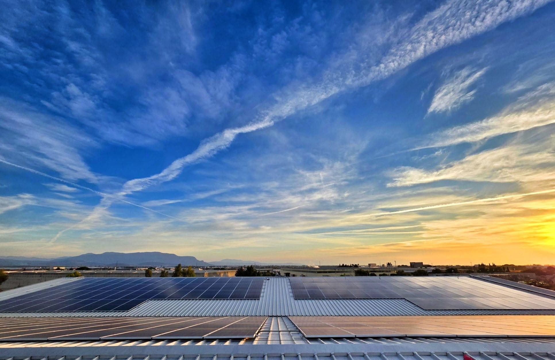 Impianto fotovoltaico su un capannone industriale al tramonto