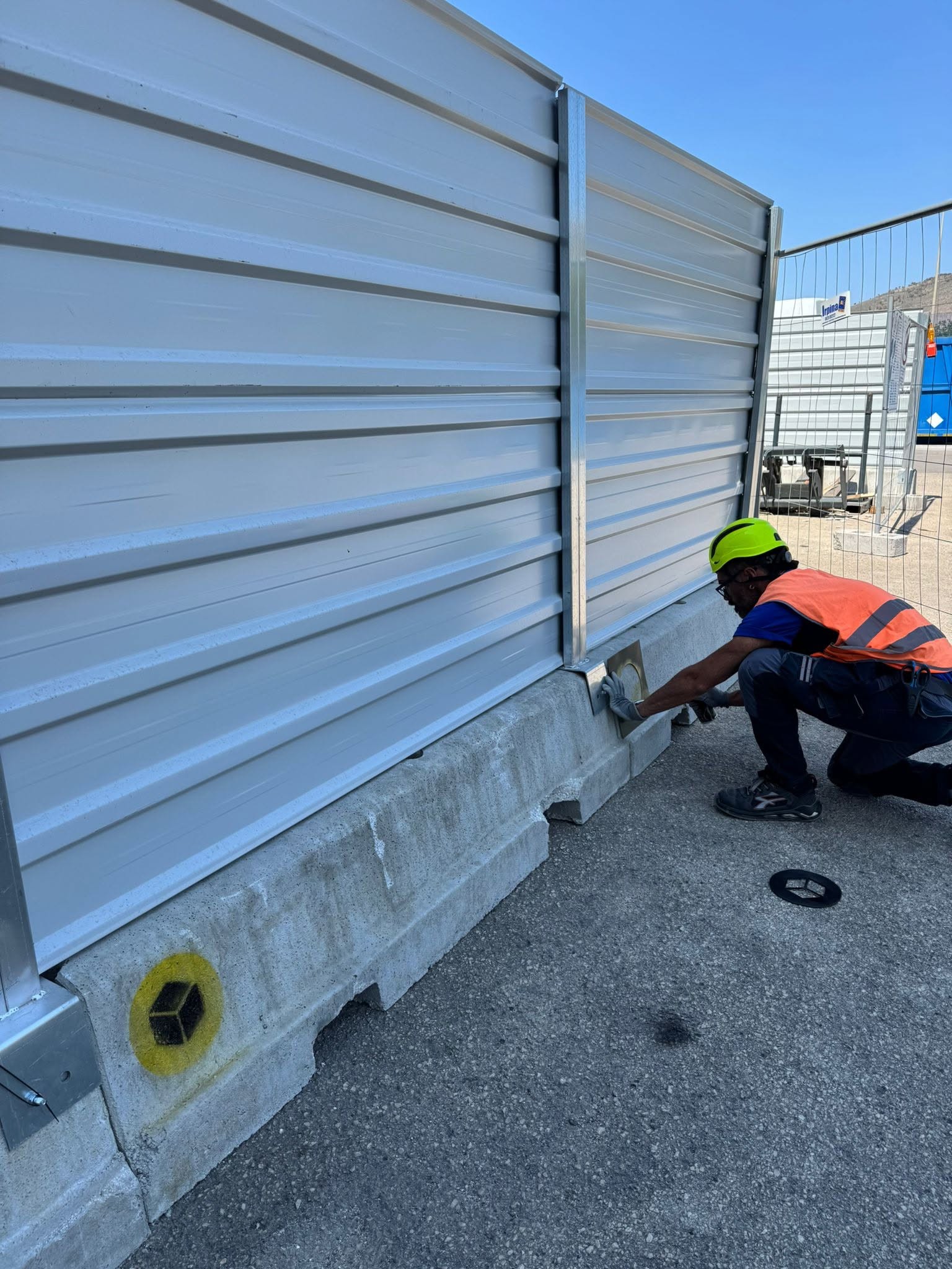 Tecnico Novare durante la posa di una recinzione a pannelli