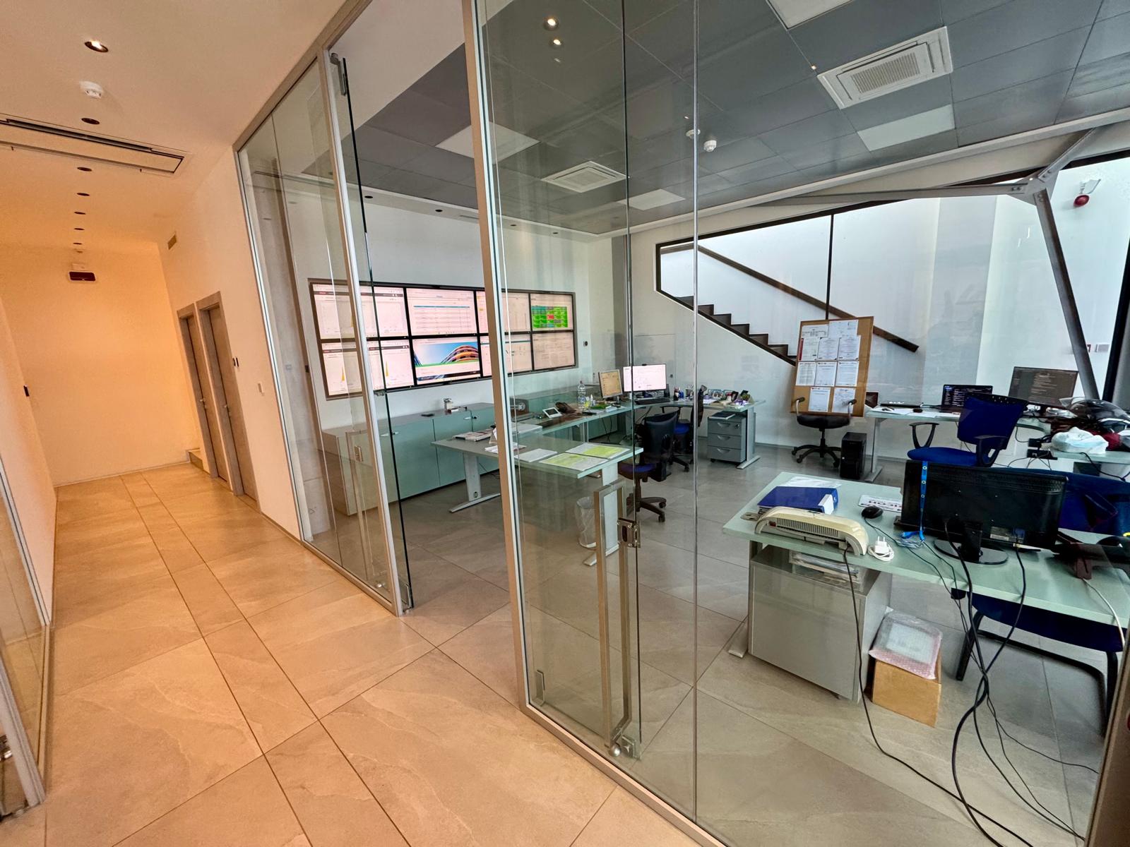 Uffici tecnici della sede Novare con pareti vetrate e videowall di monitoraggio